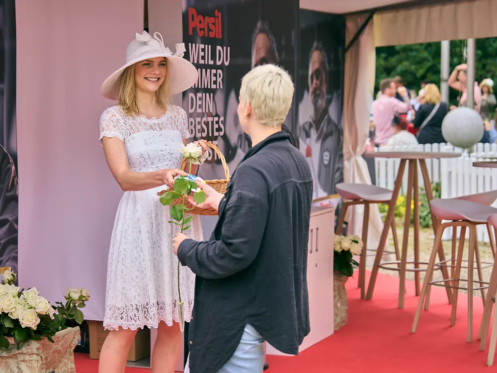 
Die weiße Dame von Persil verteilte Rosen an Besucher:innen.